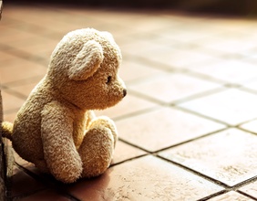 Kleiner Teddybär bei gefliesten Stufen