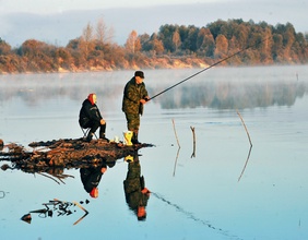 Sitzende Frau neben fischenden Mann in Yuzefovo