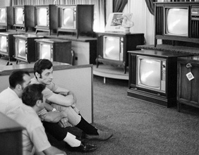 Historisches Fotos von Menschen beim Betrachten der TV-Übertragung der Mondlandung