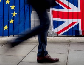 Passant vor EU- und UK-Fahnen