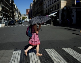 Frau mit Schirm in der Pariser Sommerhitze