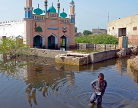 Ein junge wartet durch das Hochwasser in Pakistan.