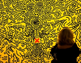"Aids" von Keith Haring, von einer Frau betrachtet
