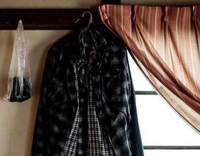 Kodokushi, vereinsamte Wohnung eines alten Menschen in Japan, hängende Hemden und Vorhang, Tatamiwände