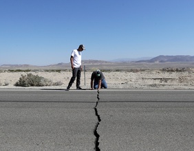 Arbeiter untersuchen eine Straße nach einem Erdbeben