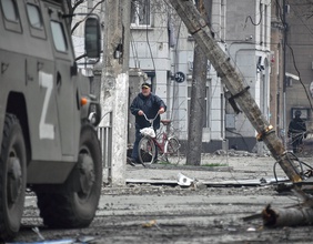 Ein Mann schiebt sein Fahrrad im Zentrum von Mariupol, Ukraine.