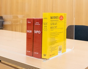 Gerichtssaal mit juristischen Sachbüchern: Kodex und StGB, StPO