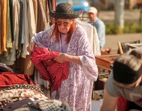 Eine Frau mit Altkleidern am Flohmarkt
