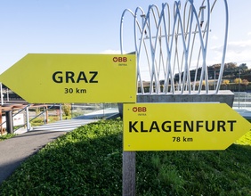 Zwei Wegweiser weisen nach Graz und Klagenfurt.