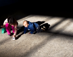 Zwei Kinder spielen am Steinboden