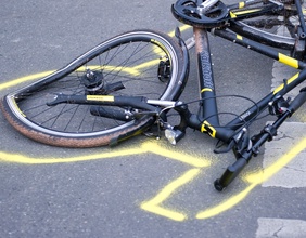 Bild eines zerknautschten Fahrrads am Boden nach einem Unfall.