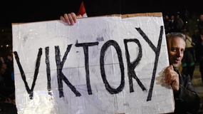 Ein Orban-Anhänger hält ein Schild in Händen mit der Aufschrift "Viktory".
