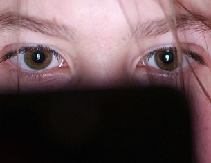 Jugendliche schaut auf einen kleinen Bildschirm