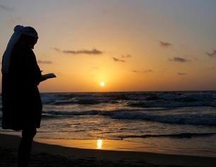 Eine jüdische Frau betet am Strand während Rosch Haschana
