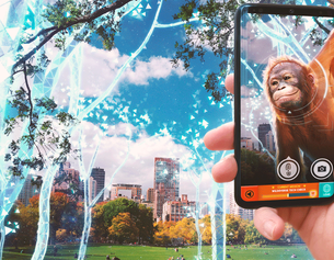 Screenshot eines Augmented Reality Games. Auf einem Smartphone sieht man einen Orang-Utan, dahinter virtuelle Bäume