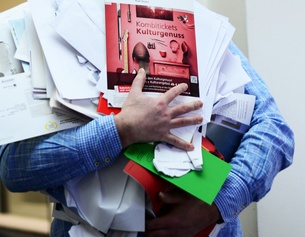 Mann trägt Altpapier