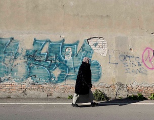 PICTUREDESK.COM/AP/LUCA BRUNO Frau mit Kopftuch vor einer Außenwand