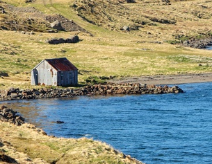 Holzhäuschen an einem Fjord in Island