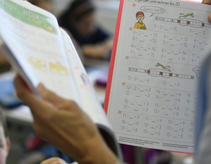 APA/HARALD SCHNEIDER Eine Lehrerin hält Schulbücher in der Hand.
