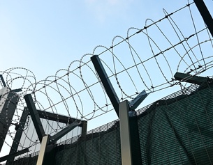 Stacheldraht entlang der Mauer einer Justizanstalt in Wien-Simmering