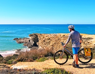 Radfahrer an einem Strand in Portugal