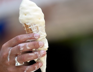 Speiseeis schmilzt auf eine Hand.