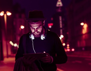 PICTUREDESK.COM/WESTEND61/UWE UMSTÄTTER Mann mit Kopfhörer und Tablet