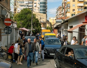 BASTIAN/CARO/PICTUREDESK.COM Auf einer Strasse in Tirana bewegen sich Menschen und Autos.