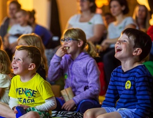 Kinder lachen beim Film schauen am Kinder Kurzfilm Festival