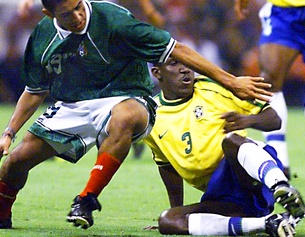 APA/AFP/Cris BOURONCLE Ein mexikanischer und ein brasilianischer Nationalspieler kämpfen um den Ball