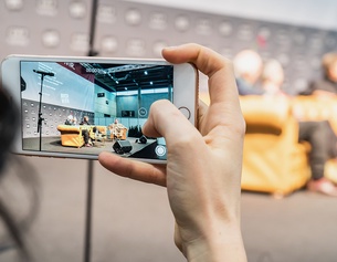 ORF/JOSEPH SCHIMMER Frau hält Handy in der Hand, fotografiert Bühne