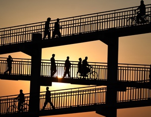 Menschen überqueren eine Fußgängerbrücke