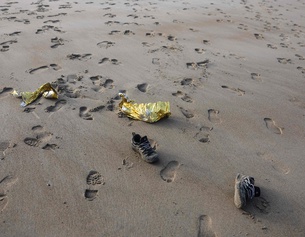 Schuhe und Spuren im Sand