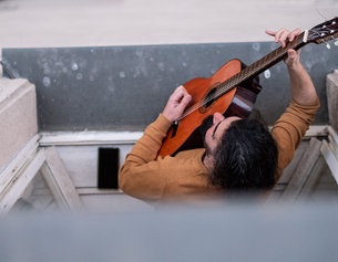 ORF/JOSEPH SCHIMMER Musiker schaut aus dem Fenster mit Gitarre