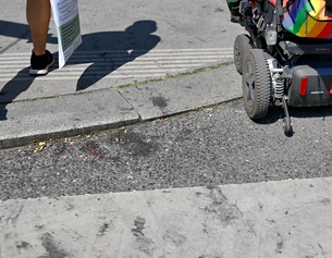 Fußgänger und Rollstuhlfahrer auf der Straße, Zebrastreifen