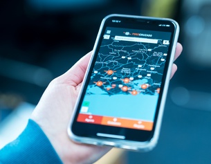 ORF / ORSINI-ROSENBERG ISABELLE Eine Hand hält ein Smartphone auf dem die App "Fogo Cruzado" geöffnet ist.