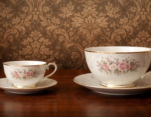 KI-Geniertes Bild: Zwei Teetassen vor Barocker Tapete