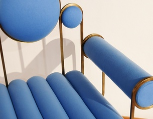 AFP/MEDINA Ein designer Sessel in blauem Stoff und Messing Rahmen.