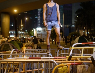 Ein junger Mann steht auf Barrikaden auf der Strasse in Hongkong.