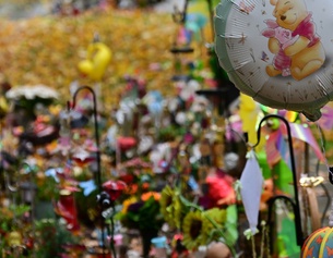 Grab eines kleines Kindes mit Luftballon und kleinen bungen Bällen