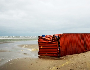 ANP/AFP/REMKO DE WAAL Ein gestrandeter zerbeulter Container.