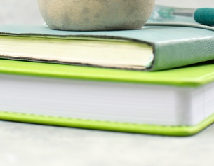 Buchstapel und Kugelschreiber