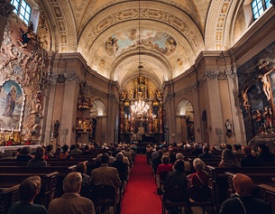 NIKLAS SCHNAUBELT Menschen sitzen in einer Kirche.