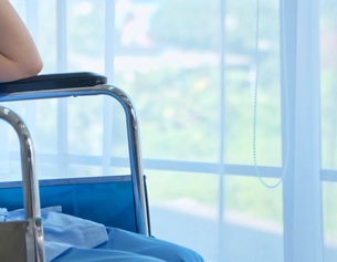 Dame in einem Rollstuhl in einem Krankenhaus am Fenster