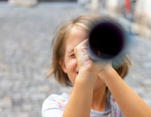 Mädchen schaut durch ein Fernrohr