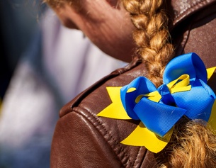 Junges Mädchen mit Zopf und Masche in den Farben der Ukraine