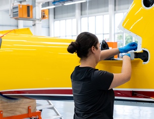 Eine weibliche Fachkraft montiert in einer Industriehalle etwas