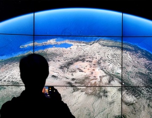 AFP/TIMOTHY A. CLARY Ein Mann steht vor einem Bildschirm von Google Earth.