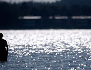 Eine Person im Wasser am Strand in Finnland