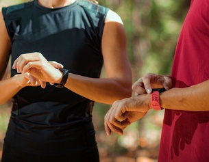 Zwei Personen schauen auf ihre Smartwatch